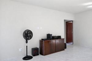 a white room with a fan and a cabinet at Casa privativa em Itaúna in Saquarema