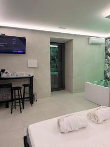 卡塔尼亚Haven Home Suite & Spa的一间酒店房间，墙上有一张床和一台电视 更多13张照片