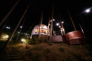 a tree house at night with two large barrels at Nad Narvią - Glamp in Serock +16 photos