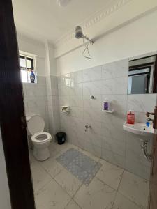 a white bathroom with a toilet and a sink at NikLan Homes in Naivasha