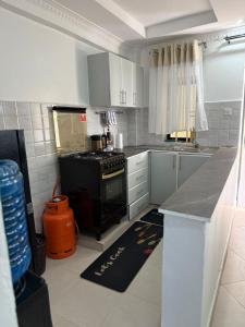 a kitchen with a black stove and white cabinets at NikLan Homes in Naivasha