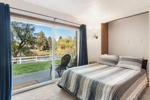 a bedroom with a bed and a large window at Ground Floor - Riverfront Studio in Bend