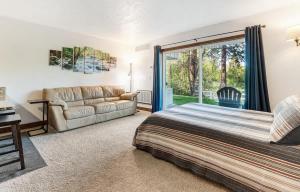a bedroom with a bed and a couch at Ground Floor - Riverfront Studio in Bend