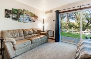 a living room with a couch and a large window at Ground Floor - Riverfront Studio in Bend