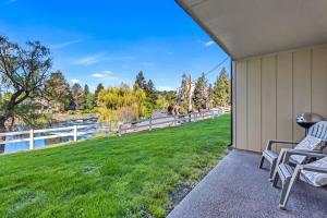 a patio with two chairs and a grassy yard at Ground Floor - Riverfront Studio in Bend