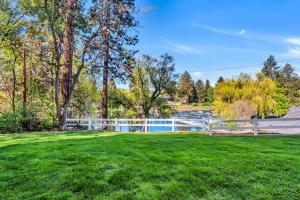 a yard with a fence and a swimming pool at Ground Floor - Riverfront Studio in Bend +28 photos