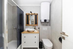 ein Badezimmer mit Waschbecken, Toilette und Spiegel in der Unterkunft Villa Agora - Betina in Betina + 32 Fotos