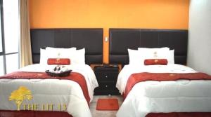 ein Hotelzimmer mit zwei Betten und einem Fenster in der Unterkunft The lit 13 in Querétaro