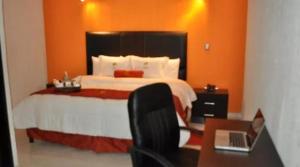 ein Schlafzimmer mit einem Bett und einem Schreibtisch mit einem Laptop in der Unterkunft The lit 13 in Querétaro