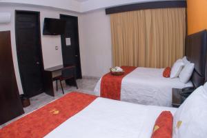 ein Hotelzimmer mit zwei Betten und einem Flachbildfernseher in der Unterkunft The lit 13 in Querétaro