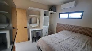 una camera da letto con un letto, uno specchio e una finestra di Casa Cielo a Todos los Santos