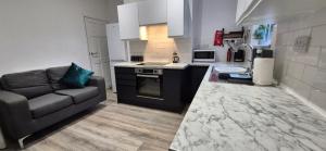 een woonkamer met een bank en een keuken bij St Johns - 2 Bed House in Balby +4 foto's