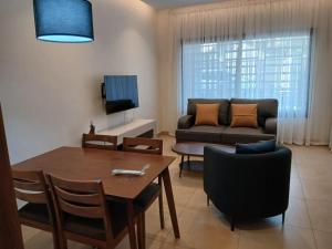 ein Wohnzimmer mit einem Tisch und einem Sofa in der Unterkunft Residence Helice in Kinshasa