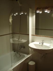 a bathroom with a sink and a shower and a mirror at Posada Las Puentes in Barcenilla