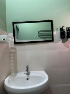 a mirror above a white sink in a bathroom at Humble abode Homestay 1BHK with scenic view in Itānagar
