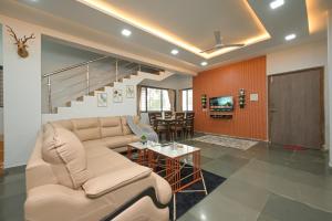 ein Wohnzimmer mit Sofa und Tisch in der Unterkunft ll EMPYREAN STAY ll 3BHK ll CELESTIAL UNICORN VILLA ll AC ll PRIVATE POOL ll LUXURY ll in Lonavla