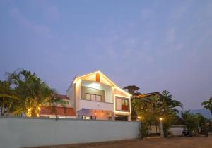 ein Haus mit einem weißen Zaun davor in der Unterkunft ll EMPYREAN STAY ll 3BHK ll CELESTIAL UNICORN VILLA ll AC ll PRIVATE POOL ll LUXURY ll in Lonavla