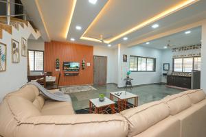 ein Wohnzimmer mit Sofa und Fernseher in der Unterkunft ll EMPYREAN STAY ll 3BHK ll CELESTIAL UNICORN VILLA ll AC ll PRIVATE POOL ll LUXURY ll in Lonavla