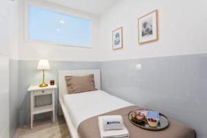 a small bedroom with a bed with a tray of food on it at Authentic Retreat by HostWise in Porto