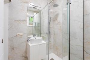 a bathroom with a sink and a glass shower at Authentic Retreat by HostWise in Porto
