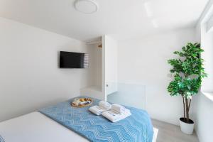 a room with a bed with towels and a plant at Authentic Retreat by HostWise in Porto +13 photos