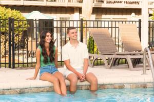 a man and a woman sitting in a swimming pool at Pool - Ocean View - Walk to Beach - Captain Villa in Fripp Island