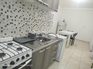 una cucina con fornelli, lavello e tavolo di Departamento en San Luis, Capital a San Luis