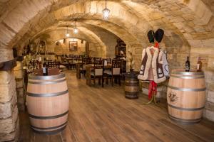 Una bodega con barriles y una mesa y sillas. en Wine Garden Hotel Comrat, en Komrat
