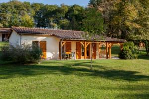 een klein huis in een veld met een grasveld bij Camping 5 étoiles - Piscine - ccbefbi in Gourdon-en-quercy