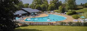 een groot zwembad met parasols en mensen erin bij Camping 5 étoiles - Piscine - ccbefbi in Gourdon-en-quercy