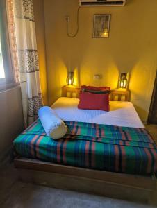 een slaapkamer met een bed met kleurrijke lakens en kussens bij Kadella Eco Villa in Beliatta