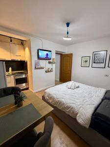 a bedroom with a bed and a table and a tv at Krid Tirana Studio Flat in Tirana