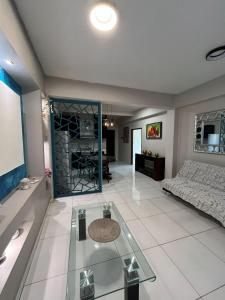 ein Wohnzimmer mit einer Couch und einem Glastisch in der Unterkunft Departamento en Cuernavaca in Cuernavaca