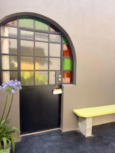 a black door with a window and a yellow bench at Casa Josefina Hotel Boutique in Olavarría +50 photos