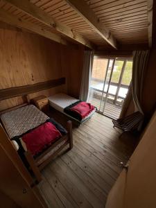 an attic room with two beds and a window at Luna & Zoé in Barra de Valizas