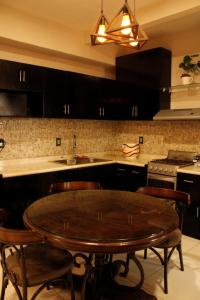 a kitchen with a wooden table and chairs in it at Departamento en Cuernavaca in Cuernavaca +8 photos