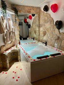 een hot tub in een kamer met een stenen muur bij Padul Suites Apartamentos in Padul