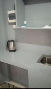a white kitchen with a sink and a counter at Casa Dwayne room 102 in Cebu City +6 photos