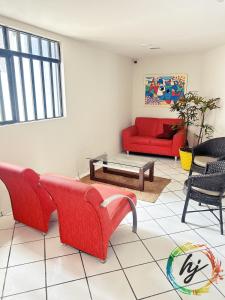 een woonkamer met een rode bank en stoelen bij Atria 304 in Tambaú