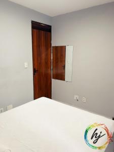 een slaapkamer met een bed en een houten deur bij Atria 304 in Tambaú +28 foto's