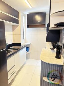 een keuken met zwart-witte toonbanken en kasten bij Atria 304 in Tambaú