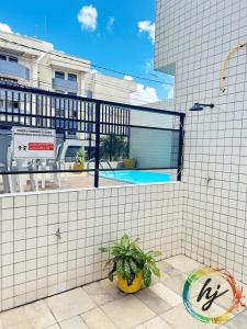 een plant in een gele pot op een witte tegelwand bij Atria 304 in Tambaú