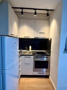 a kitchen with white cabinets and a stainless steel refrigerator at Krid Tirana Studio Flat in Tirana +7 photos