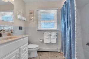 a white bathroom with a toilet and a sink at 209 4th Ave in Seaside Heights +25 photos