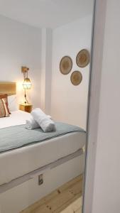 una camera con un letto e due cappelli appesi al muro di Loft acogedor junto al Roig Arena a Valencia Altre 50 foto