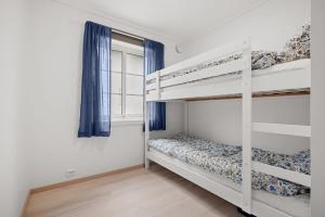 a bedroom with two bunk beds and a window at Modern Seaside Cabin Tvedestrand Hantho Brygge in Tvedestrand