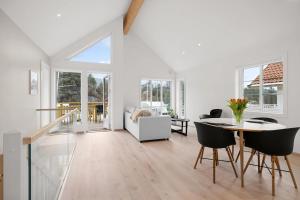 a white living room with a table and chairs at Modern Seaside Cabin Tvedestrand Hantho Brygge in Tvedestrand