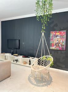 ein Wohnzimmer mit einem Hängesessel und einem TV in der Unterkunft Bela Casa Em Caldas Novas in Caldas Novas