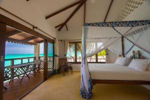 a bedroom with a bed with a view of the ocean at Warere Beach in Nungwi +168 photos