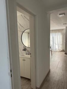 a white bathroom with a sink and a mirror at Departamentosenchascomus in Chascomús +56 photos